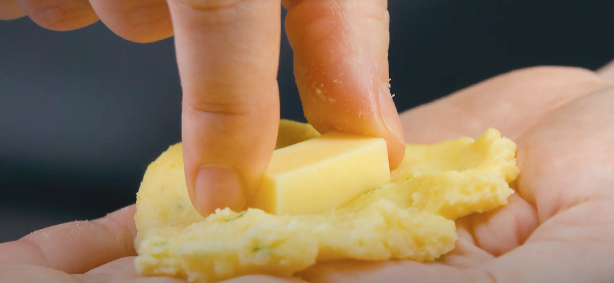 mettre un morceau de fromage dans une boulette de purée