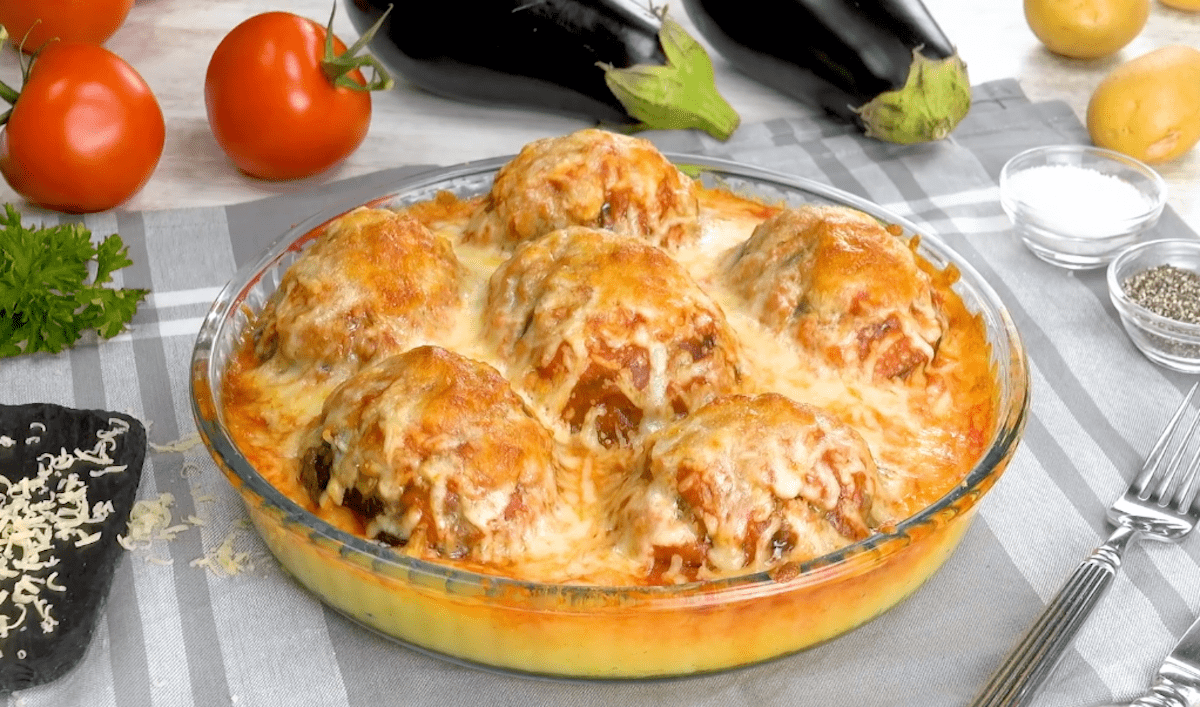 Aubergine farcie à la viande posée sur son lit de pommes de terre